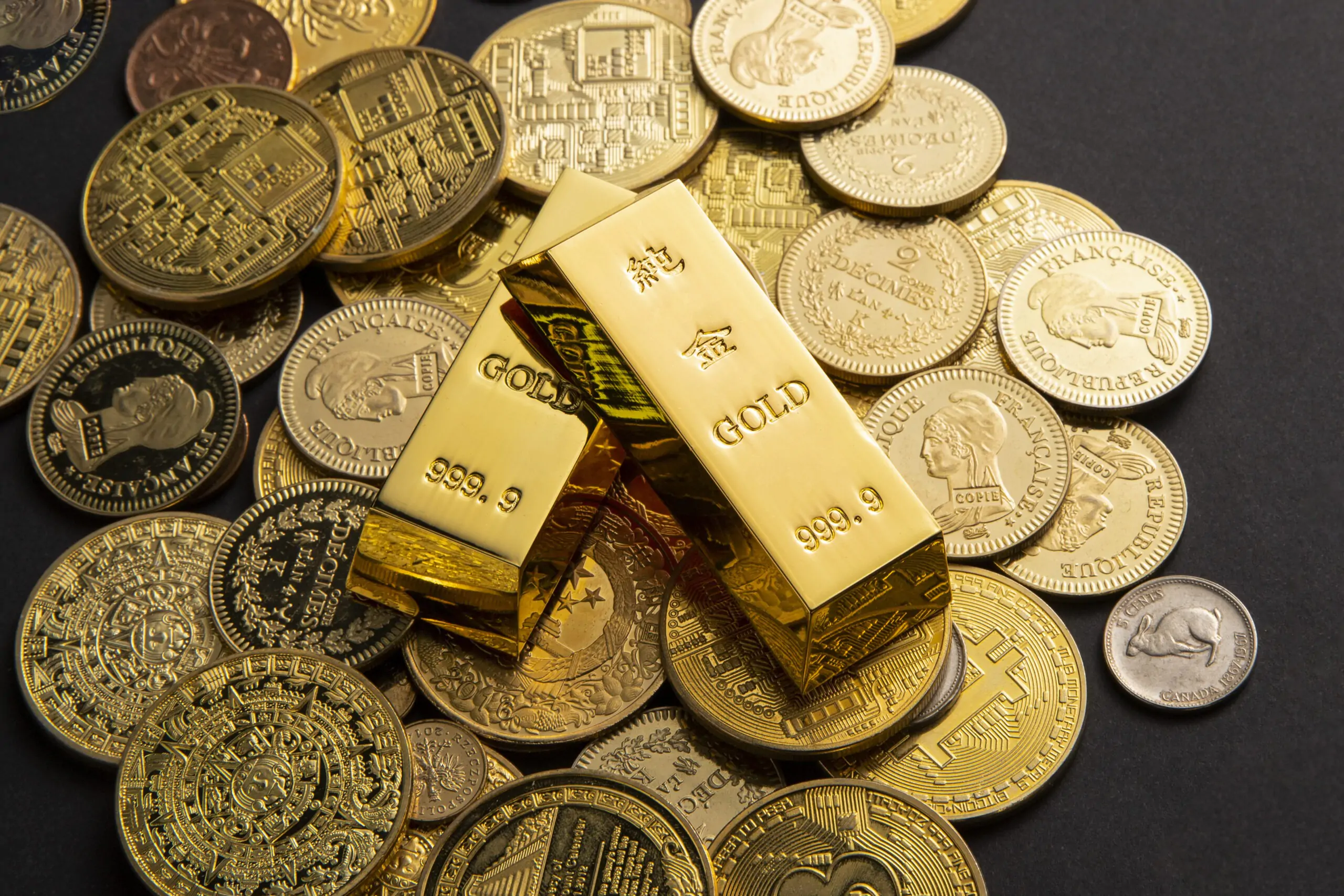Golden coins, and gold bars scattered on a table